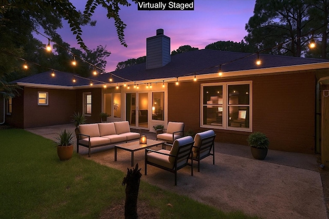 2050 Biscayne Blvd, Navarre, FL 32566 - back of property at dusk featuring a patio area, a chimney, an outdoor living space, and a lawn