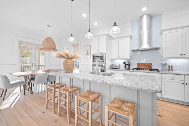 49 Clipper St, Inlet Beach, FL 32461 - kitchen with wall chimney exhaust hood, stainless steel microwave, a breakfast bar area, crown molding, and light wood-style flooring