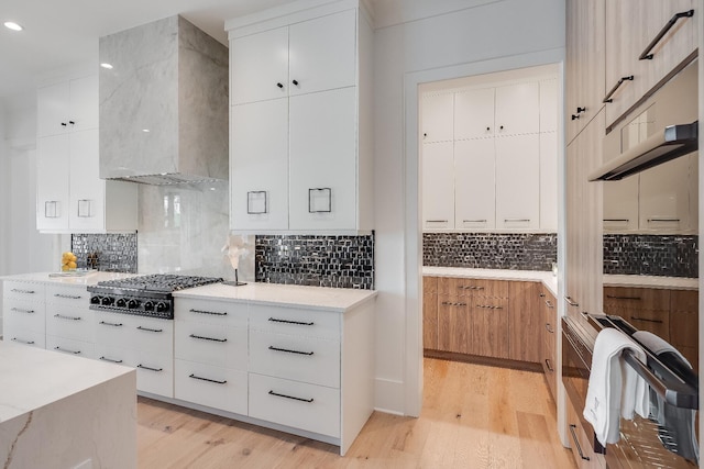 83 Norman Ct, Inlet Beach, FL 32461 - kitchen featuring gas cooktop, wall chimney range hood, light wood-type flooring, modern cabinets, and tasteful backsplash