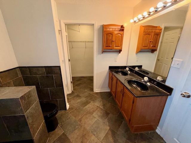 7167 Manatee St, Navarre, FL 32566 - bathroom with double vanity, stone finish floors, and a walk in closet
