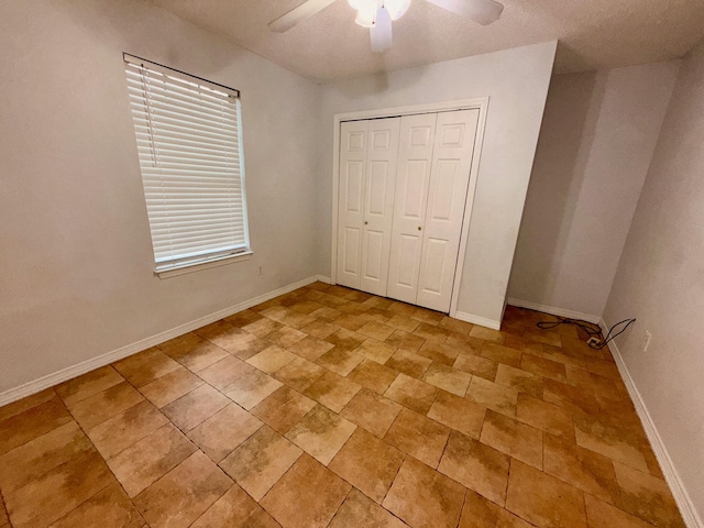 7167 Manatee St, Navarre, FL 32566 - unfurnished bedroom with a ceiling fan, a closet, and light stone finish floors
