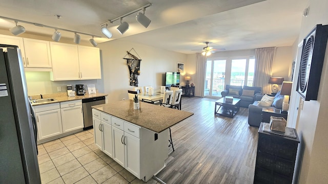 9902 S Thomas Dr Unit 933, Panama City Beach, FL 32408 - kitchen featuring stainless steel appliances, ceiling fan, white cabinets, light stone counters, and open floor plan