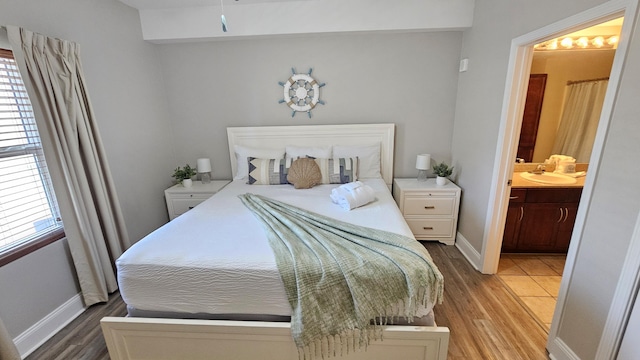 9902 S Thomas Dr Unit 933, Panama City Beach, FL 32408 - bedroom with light wood-type flooring and ensuite bathroom