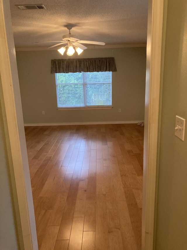 4627 Windstarr Dr, Destin, FL 32541 - spare room featuring ornamental molding, a ceiling fan, light wood-type flooring, and a textured ceiling