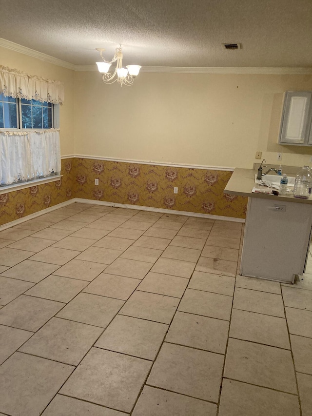 4627 Windstarr Dr, Destin, FL 32541 - unfurnished dining area with a textured ceiling, a chandelier, ornamental molding, wainscoting, and light tile patterned flooring
