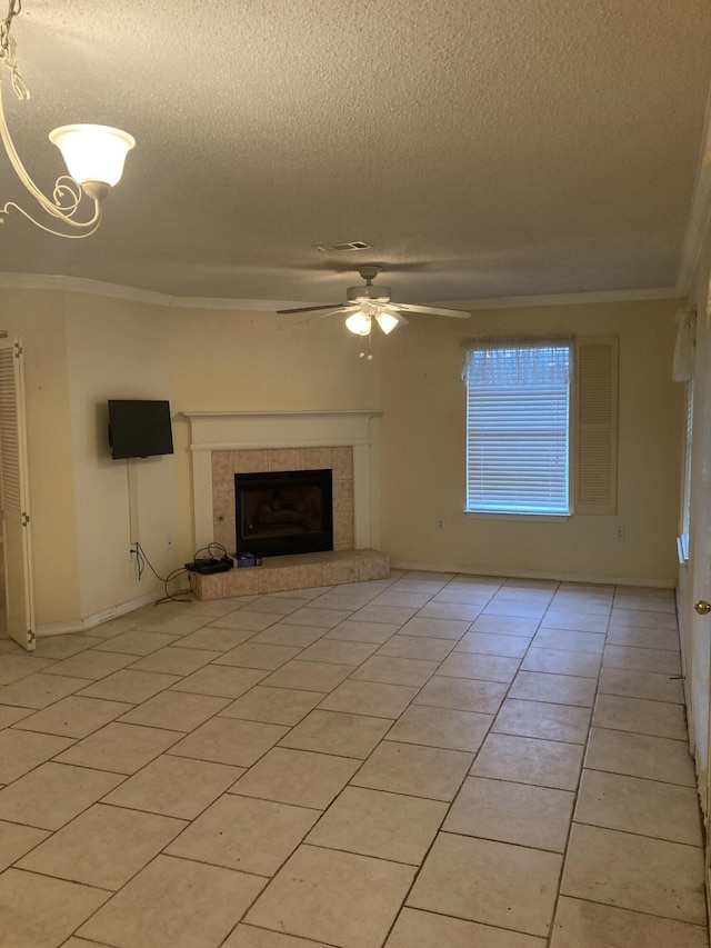 4627 Windstarr Dr, Destin, FL 32541 - unfurnished living room featuring a textured ceiling, ornamental molding, ceiling fan, a tiled fireplace, and light tile patterned flooring