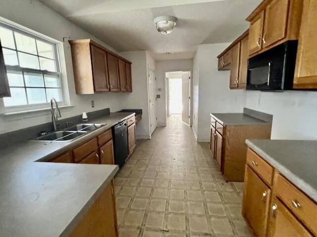 5151 Eagle Way, Crestview, FL 32539 - kitchen with black microwave, dishwashing machine, brown cabinets, and light floors