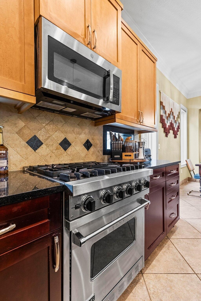 37 Conch Cay, Destin, FL 32541 - kitchen featuring appliances with stainless steel finishes, tasteful backsplash, ornamental molding, dark stone countertops, and light tile patterned flooring