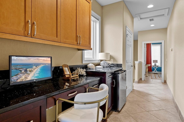 37 Conch Cay, Destin, FL 32541 - kitchen with light tile patterned flooring, dark stone counters, brown cabinets, and refrigerator