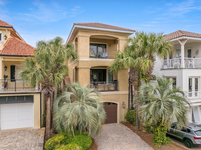 37 Conch Cay, Destin, FL 32541 - view of front facade featuring an attached garage, decorative driveway, stucco siding, a balcony, and a tile roof
