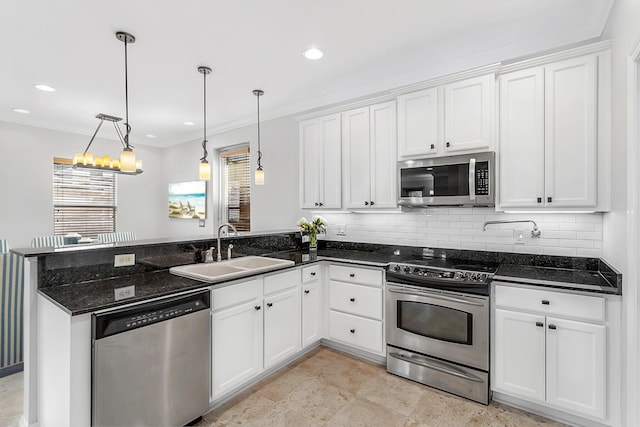 4739 Amhurst Cir, Destin, FL 32541 - kitchen with appliances with stainless steel finishes, a peninsula, white cabinetry, tasteful backsplash, and ornamental molding