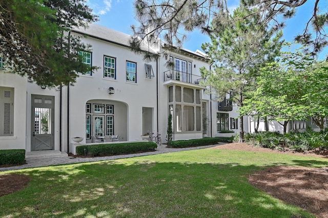 37 Sugar Loaf Aly, Alys Beach, FL 32461 - back of house featuring a lawn and stucco siding