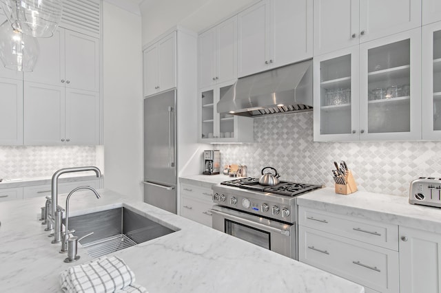 37 Sugar Loaf Aly, Alys Beach, FL 32461 - kitchen with range hood, high end appliances, decorative backsplash, white cabinetry, and light stone countertops