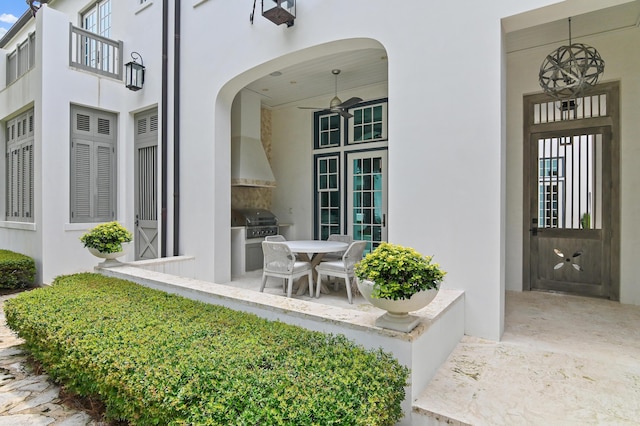 37 Sugar Loaf Aly, Alys Beach, FL 32461 - view of exterior entry featuring an outdoor kitchen, stucco siding, a balcony, outdoor dining area, and a patio area