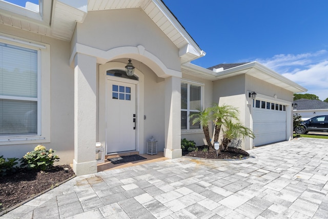 1009 Forest Shore Dr, Miramar Beach, FL 32550 - property entrance with stucco siding, an attached garage, and decorative driveway
