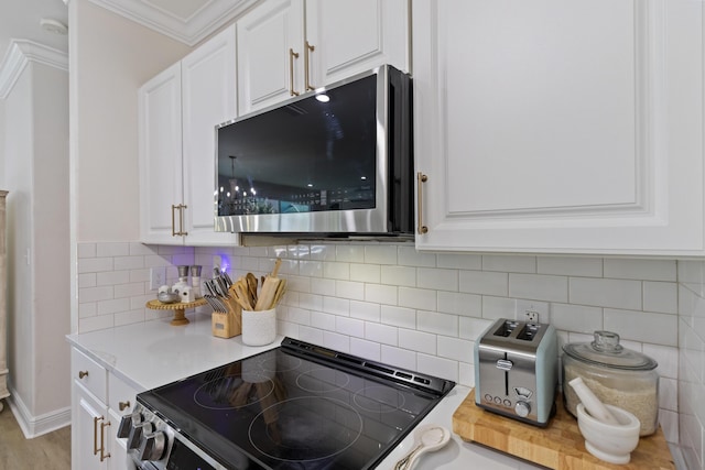 1009 Forest Shore Dr, Miramar Beach, FL 32550 - kitchen featuring stainless steel microwave, range with electric cooktop, white cabinetry, and ornamental molding
