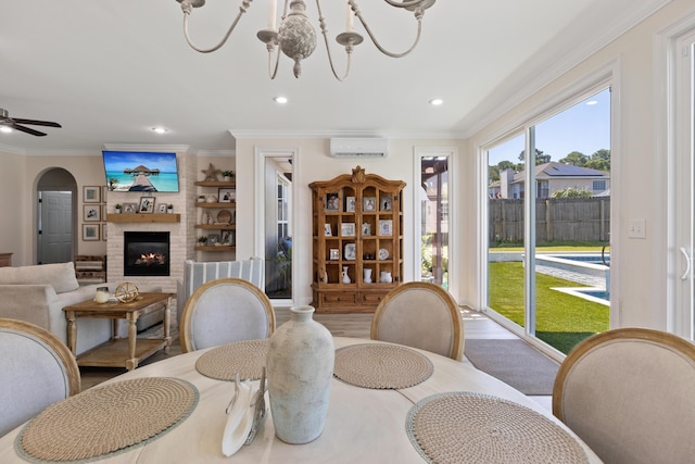 1009 Forest Shore Dr, Miramar Beach, FL 32550 - dining space with a chandelier, a brick fireplace, a wall unit AC, ornamental molding, and recessed lighting