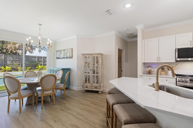 1009 Forest Shore Dr, Miramar Beach, FL 32550 - dining room featuring a chandelier, light wood-style floors, crown molding, and recessed lighting
