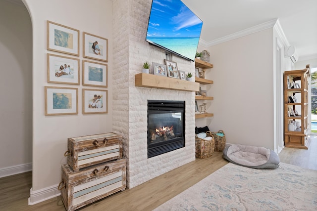 1009 Forest Shore Dr, Miramar Beach, FL 32550 - living room featuring a stone fireplace, crown molding, wood finished floors, and arched walkways