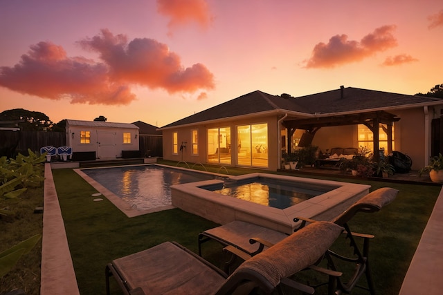1009 Forest Shore Dr, Miramar Beach, FL 32550 - pool at dusk featuring an in-ground hot tub, an outdoor structure, a fenced backyard, and a patio area
