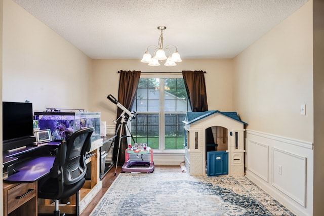 2808 Ping Ln, Crestview, FL 32539 - office space with a chandelier, wood finished floors, wainscoting, a textured ceiling, and a decorative wall