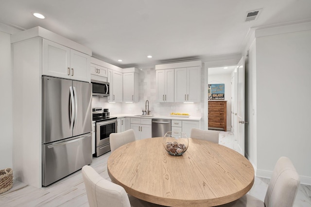 65 Sandy Shores Ct, Inlet Beach, FL 32461 - kitchen with stainless steel appliances, recessed lighting, white cabinetry, light countertops, and ornamental molding