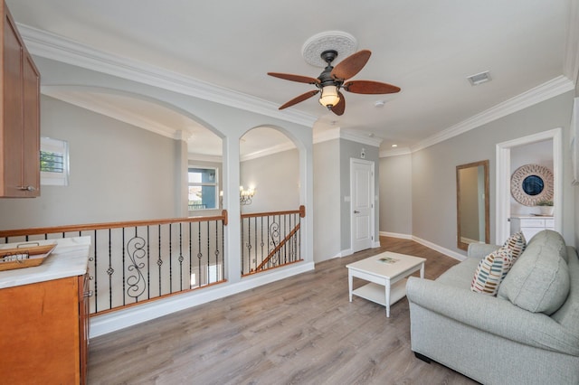 102 Terra Cotta Way, Destin, FL 32541 - living room featuring ceiling fan, ornamental molding, light wood finished floors, and arched walkways