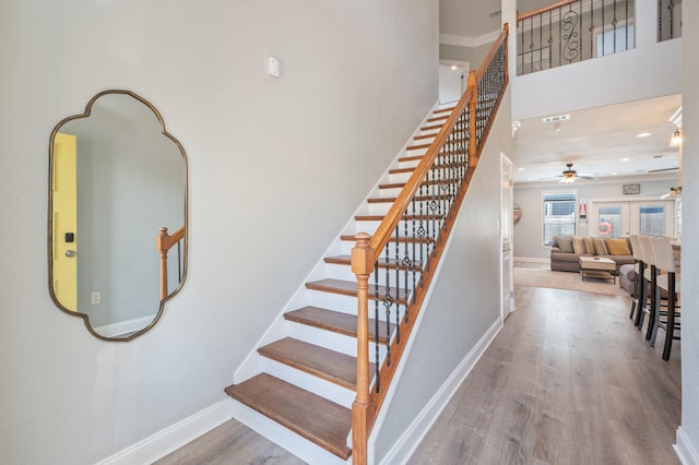 102 Terra Cotta Way, Destin, FL 32541 - stairs with ceiling fan, wood finished floors, a towering ceiling, crown molding, and recessed lighting