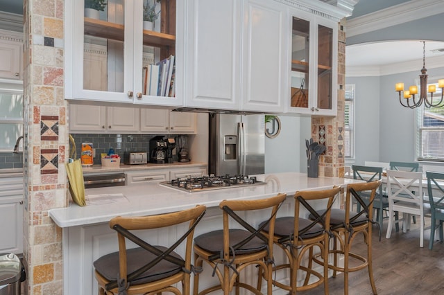 102 Terra Cotta Way, Destin, FL 32541 - kitchen with appliances with stainless steel finishes, crown molding, white cabinets, a chandelier, and wood finished floors