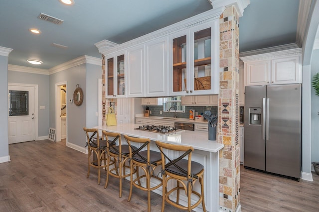 102 Terra Cotta Way, Destin, FL 32541 - kitchen featuring stainless steel appliances, ornamental molding, backsplash, white cabinets, and light countertops