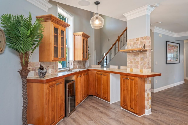 102 Terra Cotta Way, Destin, FL 32541 - bar area with wine cooler, light wood-style floors, backsplash, ornamental molding, and hanging light fixtures