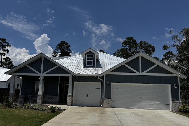 136 Hibernate Way, Freeport, FL 32439 - view of front of house with board and batten siding, a garage, driveway, a metal roof, and a porch