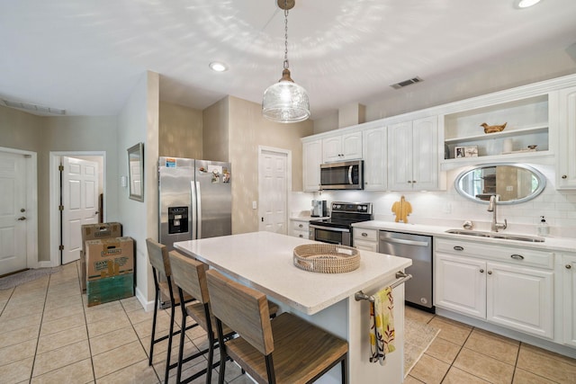 172 Shady Ln, Freeport, FL 32439 - kitchen with stainless steel appliances, light tile patterned floors, light countertops, white cabinetry, and a breakfast bar area