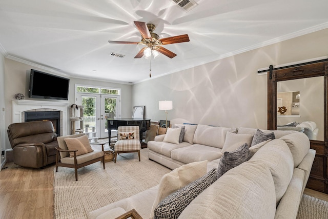 172 Shady Ln, Freeport, FL 32439 - living room with ornamental molding, light wood-style floors, french doors, ceiling fan, and a barn door