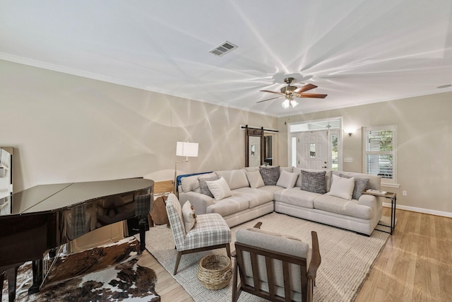172 Shady Ln, Freeport, FL 32439 - living area with light wood finished floors, a barn door, a ceiling fan, and crown molding