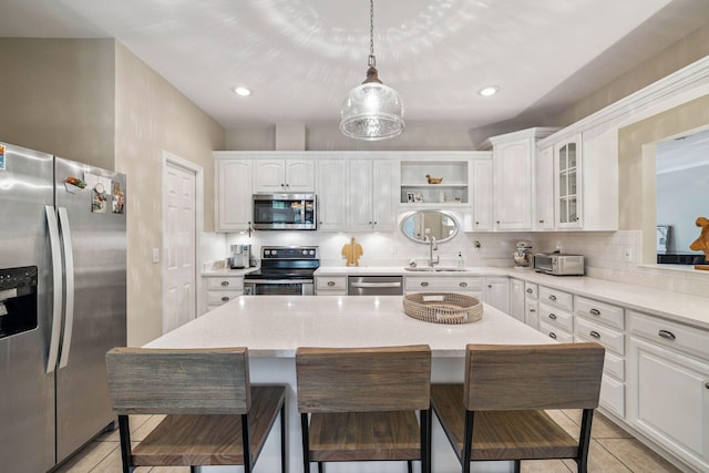 172 Shady Ln, Freeport, FL 32439 - kitchen featuring appliances with stainless steel finishes, a breakfast bar area, light tile patterned flooring, white cabinetry, and recessed lighting