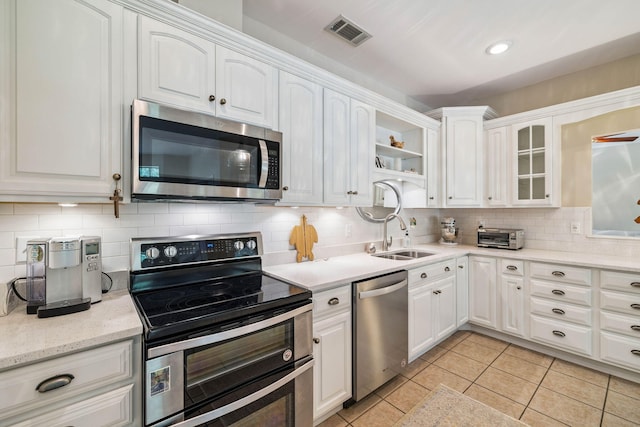 172 Shady Ln, Freeport, FL 32439 - kitchen featuring appliances with stainless steel finishes, white cabinetry, tasteful backsplash, and light tile patterned floors