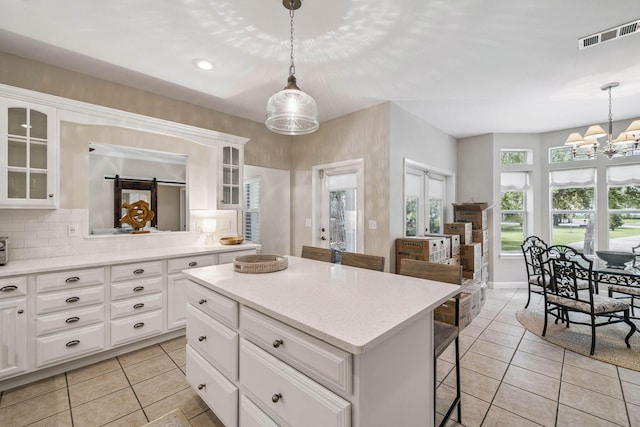 172 Shady Ln, Freeport, FL 32439 - kitchen with light tile patterned floors, a breakfast bar, a chandelier, a kitchen island, and light countertops