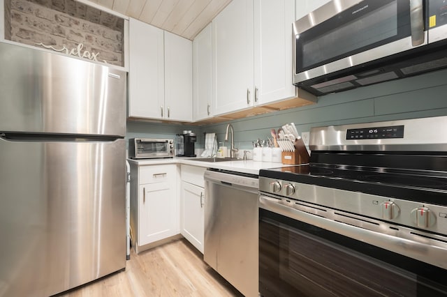 17462 Front Beach Rd Unit 18C, Panama City Beach, FL 32413 - kitchen with appliances with stainless steel finishes, white cabinets, light wood-style flooring, and light countertops