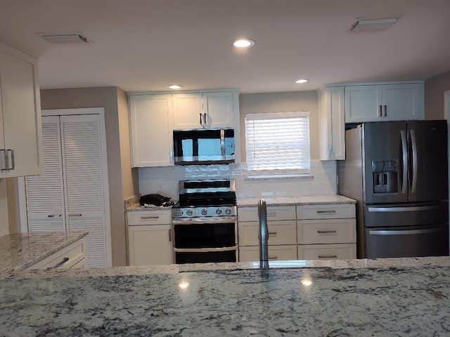 955 Scenic Gulf Dr Unit 410, Miramar Beach, FL 32550 - kitchen featuring stainless steel appliances, light stone countertops, tasteful backsplash, white cabinets, and recessed lighting