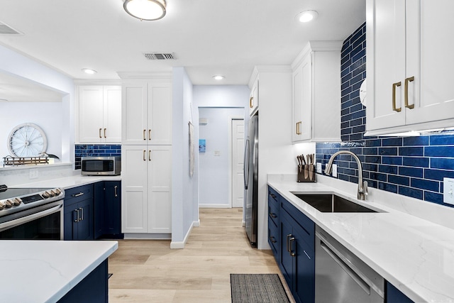 727 Sandpiper Pl # 10516, Miramar Beach, FL 32550 - kitchen with appliances with stainless steel finishes, blue cabinetry, white cabinets, backsplash, and recessed lighting