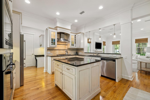 9 W Salt Box Ln, Watersound, FL 32461 - kitchen featuring appliances with stainless steel finishes, wall chimney range hood, backsplash, glass insert cabinets, and light wood-style flooring