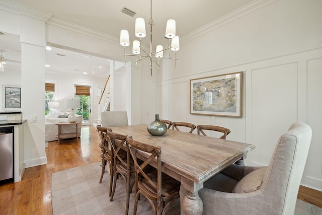 9 W Salt Box Ln, Watersound, FL 32461 - dining room featuring ornamental molding, a decorative wall, light wood-style flooring, stairway, and a chandelier