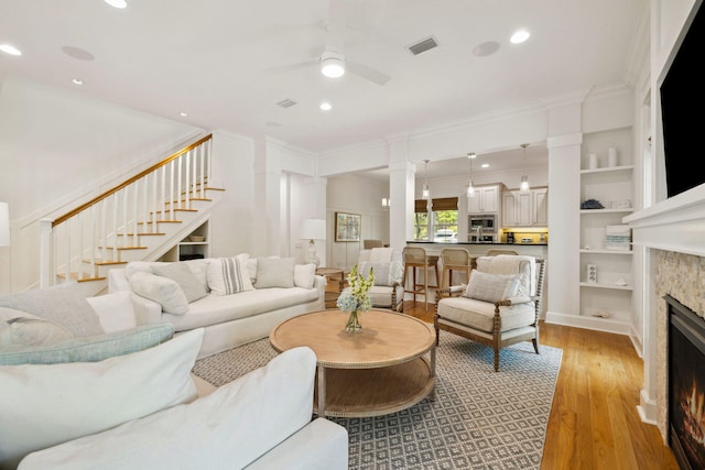 9 W Salt Box Ln, Watersound, FL 32461 - living area featuring a ceiling fan, a fireplace, stairway, light wood-style flooring, and built in shelves