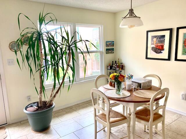4643 Windstarr Dr, Destin, FL 32541 - dining room with healthy amount of natural light, a textured ceiling, and light tile patterned floors