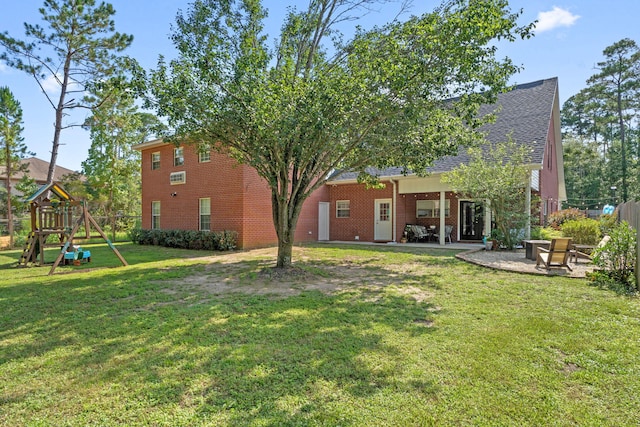3228 Mcmillan Creek Dr, Milton, FL 32583 - rear view of house featuring a playground, a patio, brick siding, and roof with shingles
