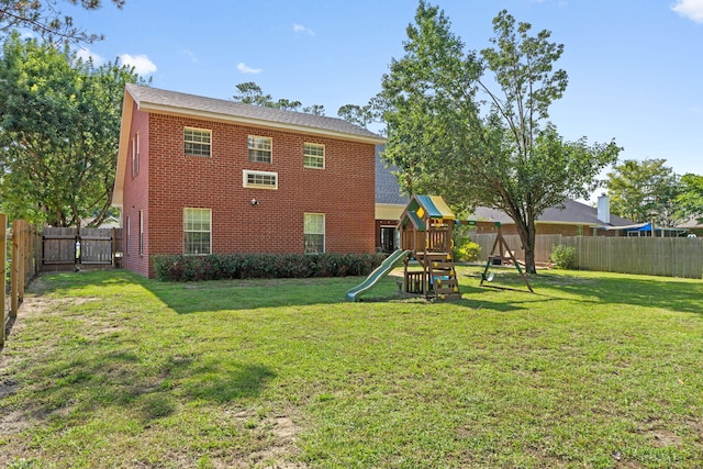 3228 Mcmillan Creek Dr, Milton, FL 32583 - rear view of house with brick siding, a playground, and a fenced backyard