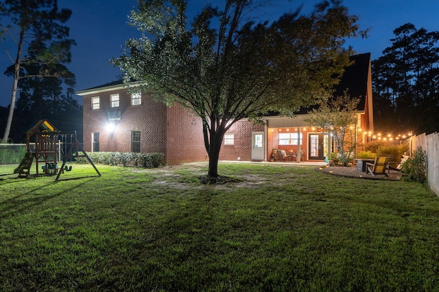 3228 Mcmillan Creek Dr, Milton, FL 32583 - back of house at twilight with a playground