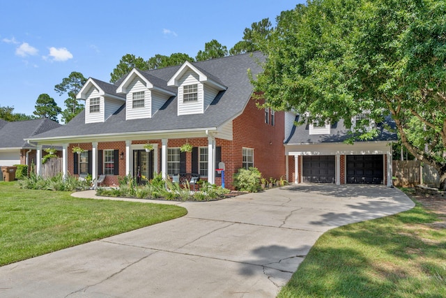 3228 Mcmillan Creek Dr, Milton, FL 32583 - cape cod house featuring brick siding, driveway, a front yard, a garage, and a porch