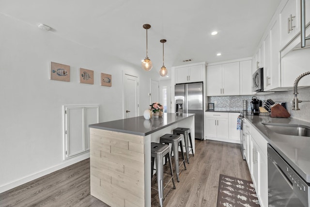 115 Gulf Winds Ct Unit 2, Destin, FL 32541 - kitchen featuring stainless steel appliances, backsplash, a breakfast bar, a center island, and light wood-type flooring